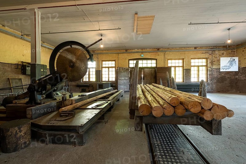 Large historic circular saw and railway carriage with logs, former paper mill and mill for the production of groundwood pulp board, UNESCO World Heritage Site Verla Factory Village, Maailmanperintökohde Verlan puuhiomo ja pahvitehdas, Verla Rapids, Kymenlaakso, near Kouvola, Finland