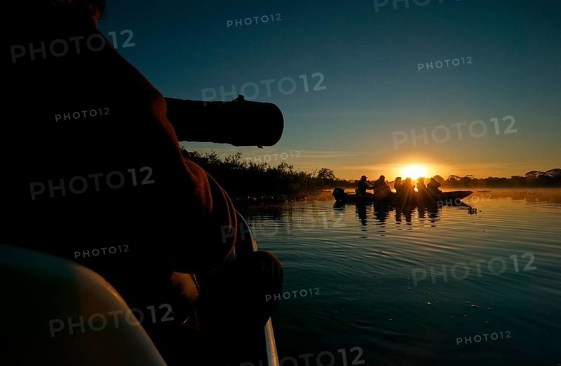Wildlife photographers in a boat on a river in the Pantanal, Brazil