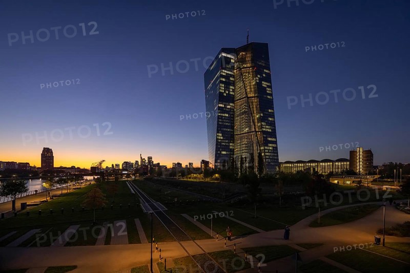 The lights of the European Central Bank (ECB) and the Frankfurt banking skyline glow in the evening, Frankfurt am Main, Hesse, Germany