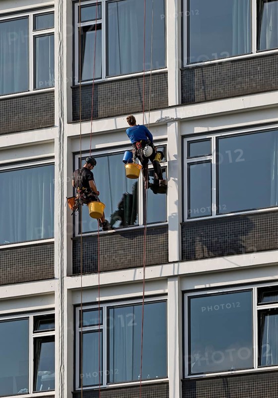 Two male glass cleaners abseiling down the hotel façade to clean windows, aletto Hotel Kudamm, Berlin, Germany
