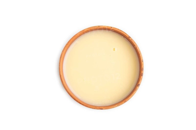 Organic non dairy banana and soy milk in clay cup isolated on white background. Vegan healthy food concept, flat lay, top view, close up