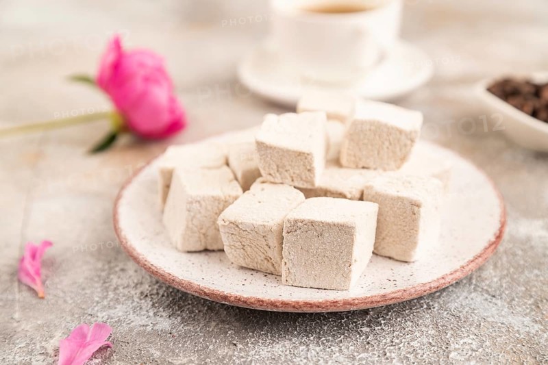 Coffee marshmallow with cup of coffee on brown concrete background. side view, close up, selective focus