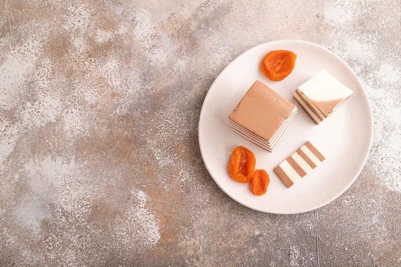 Cocoa and milk jelly with dried apricots on brown concrete background, top view, flat lay, copy space, minimalism