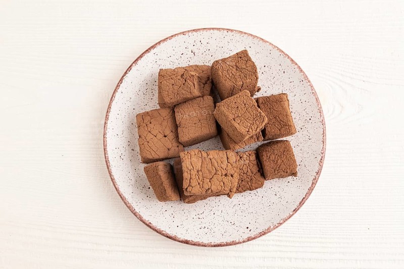 Chocolate marshmallow on white wooden background. top view, flat lay, close up