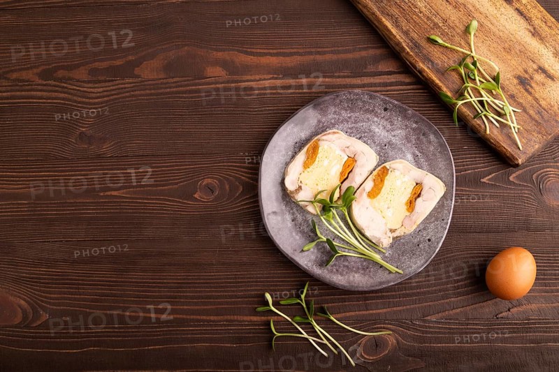 Chicken, egg and dried apricot meatloaf, microgreen on brown wooden. Diet, healthy eating. top view, copy space