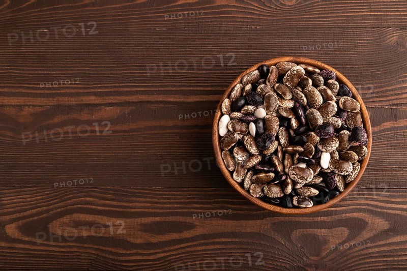 Wooden bowl with Kidney beans on brown wooden background, top view, flat lay, copy space, minimalism