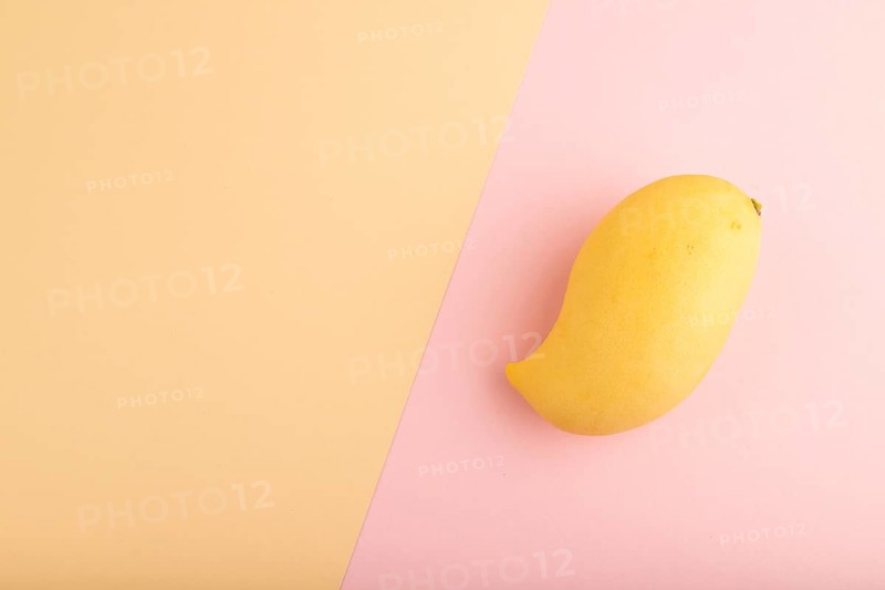 Orange mango on orange and pink paper pastel background. Top view, flat lay, copy space. healthy food, minimalism