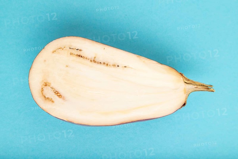 Purple Cutted eggplant with white stripes on blue pastel background. Top view, flat lay, copy space. Tropical, healthy food, vegetable, slice, minimalism