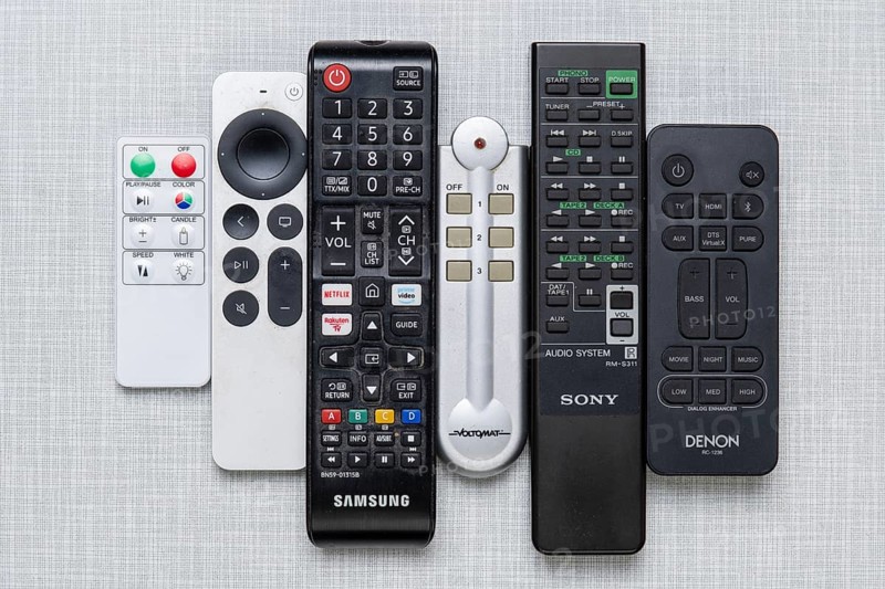 Top shot of a series of remote controls on a white Resopal panel
