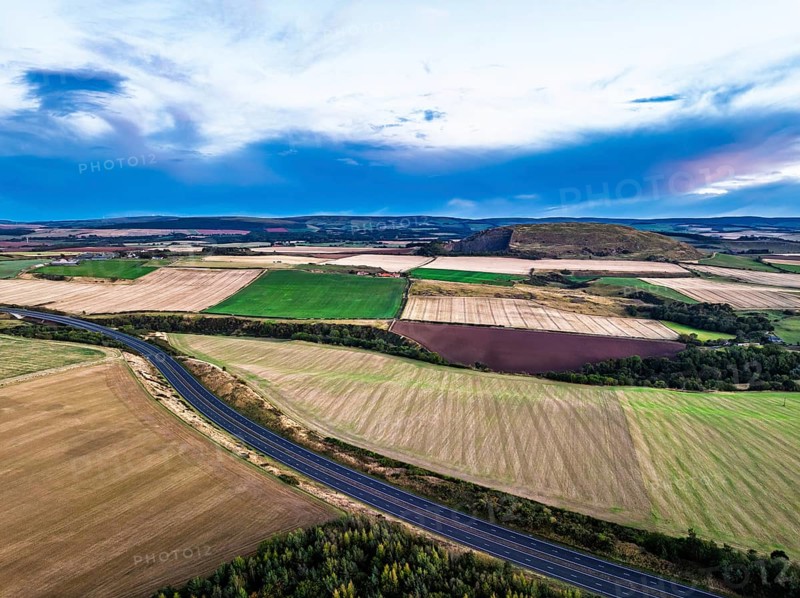 Sunset of Fields and Farms over Traprain Law and Hailes Castle from a drone, River Tyne, Haddington, East Lothian, Scotland, UK