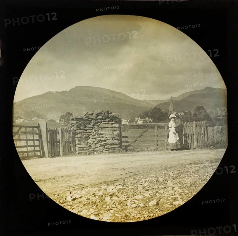 Woman Victorian or Edwardian tourist with background of Ambleside, Lake District, Cumbria, England, UK c 1900