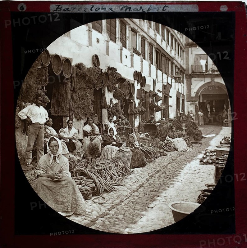 'Espartería en Almería' 1890 photographers Hermenegildo Otero and Miguel Aguirre, circular magic lantern slide mis-captioned as Barcelona, Spain. Women basket weavers and rope makers sitting in market place. Thought to be Cordoba