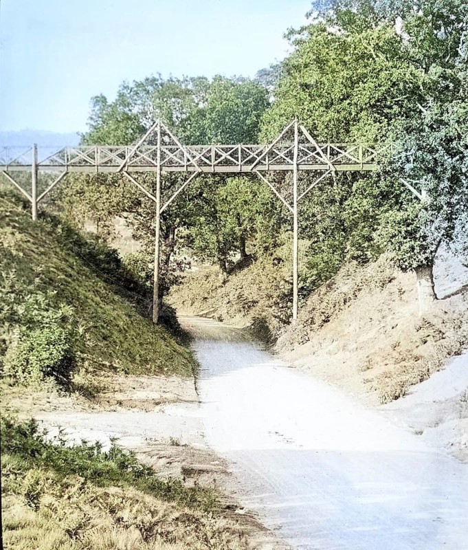 Colourised magic lantern slide of footbridge crossing the road at Wilford Hollows, Bromeswell, Suffolk, England, UK c 1910