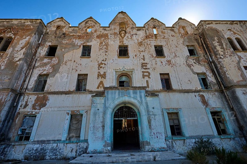 Lost Place, Frontansicht eines verlassenen Gebäudes mit geschichteten Details und verblassten Buchstaben, Caserma Avieri, Gefängnis, Konzentrationslager, Psychiatrische Klinik, Irrenanstalt, Lakki, Leros, Dodekanes, Griechische Inseln, Griechenland