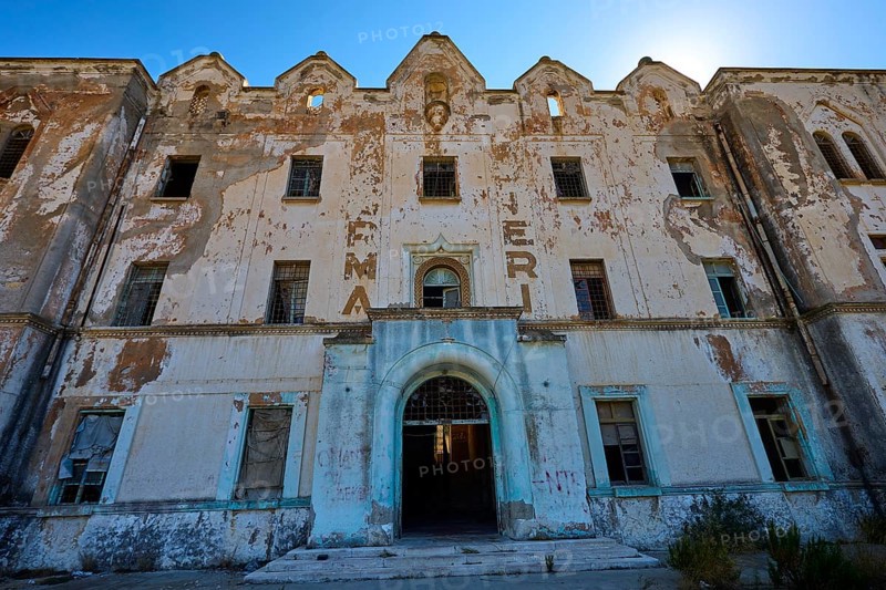 Lost Place, Verfallene Fassade eines Gebäudes mit verblassender Schrift und architektonischen Details, Caserma Avieri, Gefängnis, Konzentrationslager, Psychiatrische Klinik, Irrenanstalt, Lakki, Leros, Dodekanes, Griechische Inseln, Griechenland