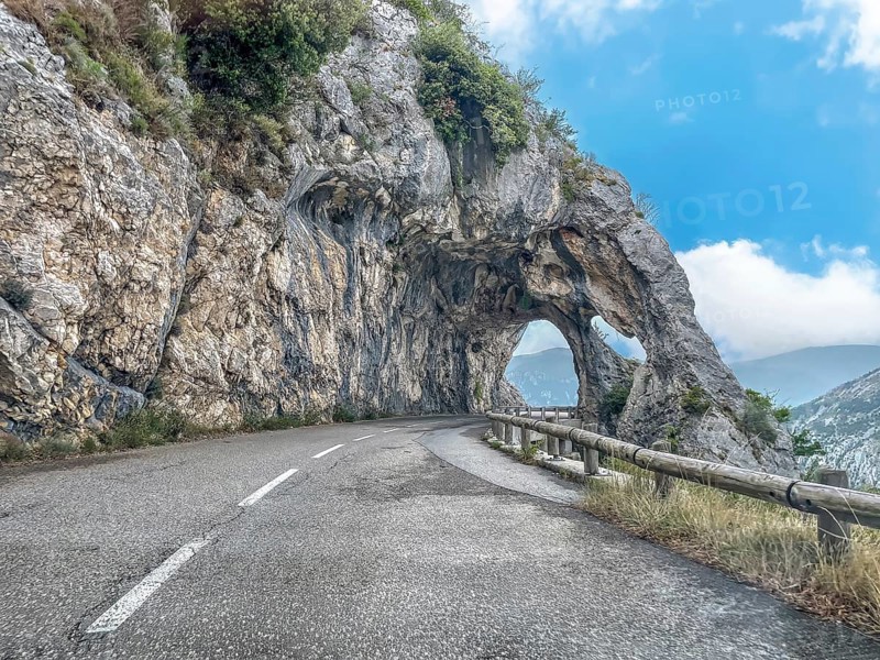View from moving car on double rock arch rock gate Arches de Gréolières in on the Route de Gentelly D2 rock formation with passage on road Route de Gentelly, Greolieres, Département Alpes-Maritimes, Region Provence-Alpes-Côte d'Azur, France