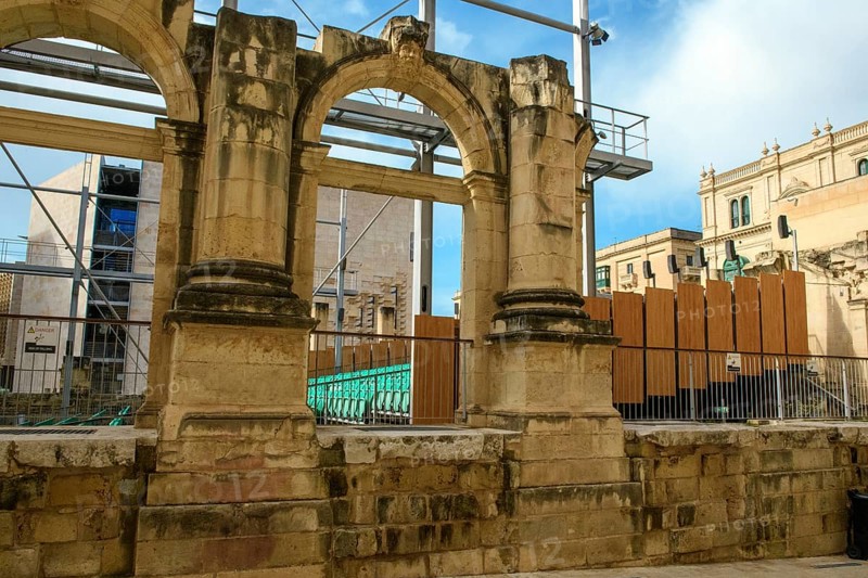 View through former arched window of ruins of former opera house Royal Opera House of Valletta destroyed in World War II on seating of integrated open-air stage, Valletta, Malta