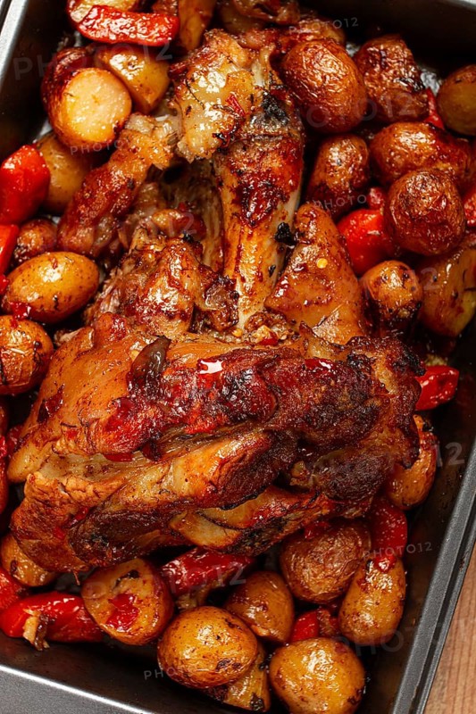 Pork knuckle, baked with vegetables, new potatoes, on a baking sheet, homemade, no people