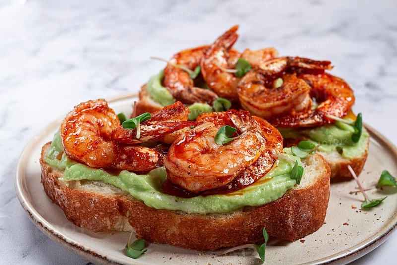 Sandwiches with avocado and caramelized shrimp, micro-greens, breakfast, on a plate, top view, homemade, no people