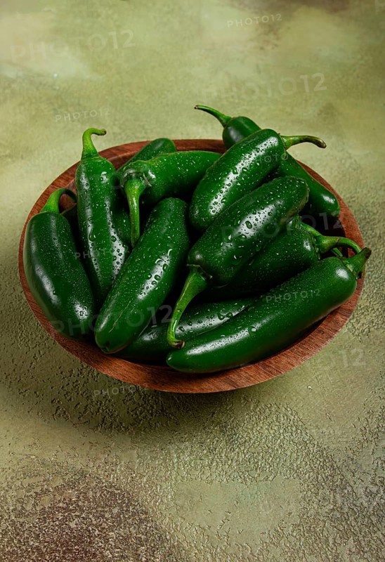 Fresh padron pepper, raw, in a wooden bowl, on the table, there are no people