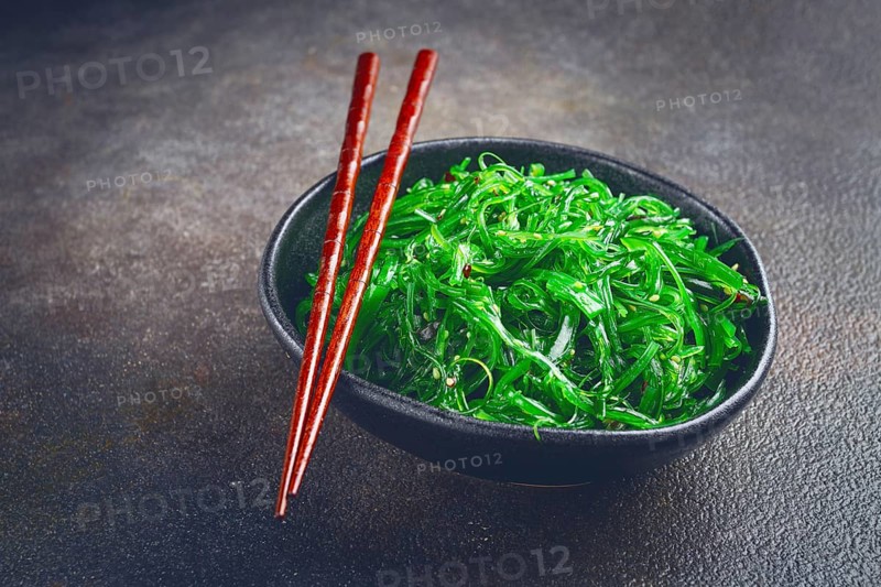 Chuka salad, made from fresh seaweed, with sesame dressing, served in a black bowl, with chopsticks