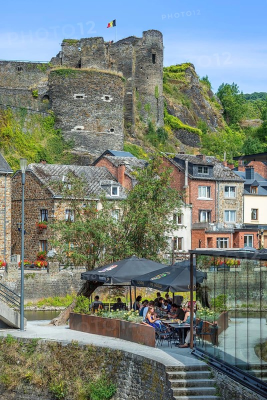 Tourists at restaurant along the river Ourthe and ruined castle in the city La Roche-en-Ardenne, province of Luxembourg, Ardennes, Wallonia, Belgium