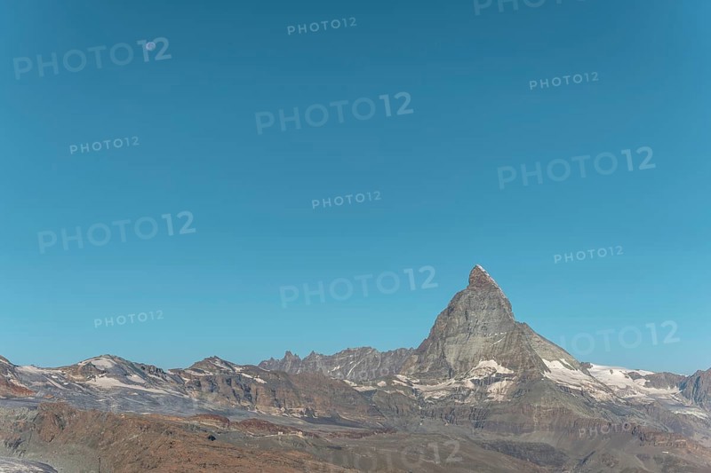 The iconic Matterhorn stands high above a clear evening sky illuminated by a bright moon. This breathtaking view captures the beauty and serenity of the Swiss Alps near Zermatt. Valais, Alps, Switzerland