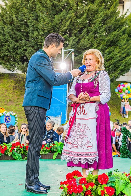 Bavarian Radio presenter Dominik Göbl in conversation with Elisabeth Polaczy, head of the historic Wiesn attraction Teufelsrad, Wiesnwirte Platzkonzert, Festwiese, Theresienwiese, Oktoberfest, Munich, Upper Bavaria, Bavaria, Germany