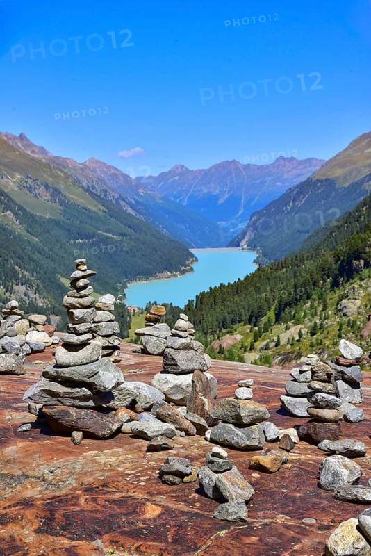 Hiking area below the Gepatsch Glacier in the Kaunertal with red rocks and the Kaunertal reservoir in the background, Ötztal Alps, Tyrol, Austria
