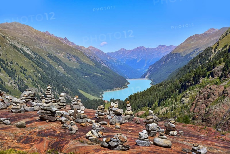 Hiking area below the Gepatsch Glacier in the Kaunertal with red rocks and the Kaunertal reservoir in the background, Ötztal Alps, Tyrol, Austria