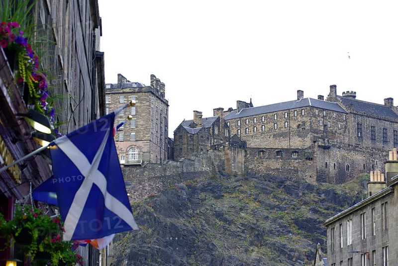 Scottish castle on a hill surrounded by buildings and a Scottish flag, Old Town, Edinburgh, Scotland, United Kingdom