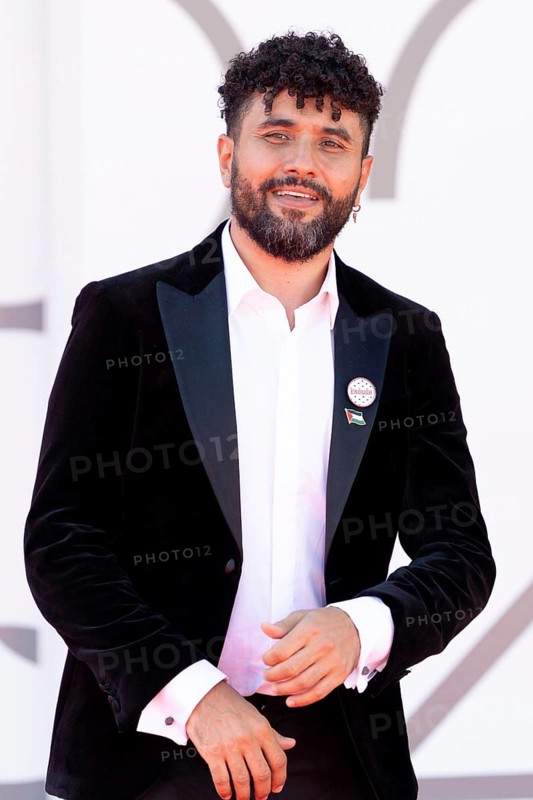Venice, Italy - 3 September 2025: Amine Bouhafa wears a sticker in the colours of the Palestine flag and a sticker with the inscription - enough - on his jacket during the red carpet of - The Voice Of Hind Rajab - during the 82nd Venice International Film Festival