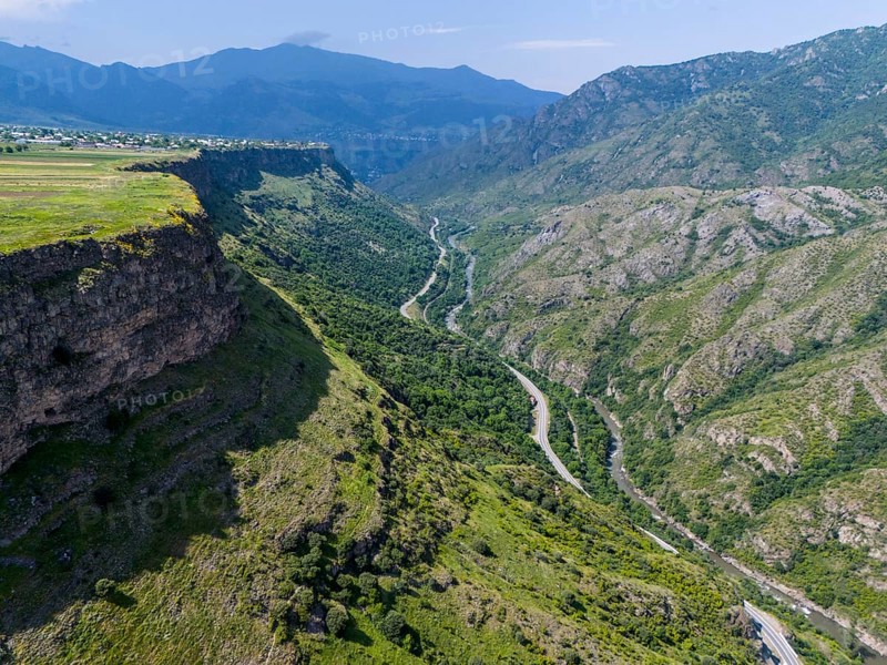 View of a picturesque valley with a river, surrounded by high mountains and lush vegetation under a blue sky, aerial view, landscape near Odsun, Odzun, Debed Gorge, Lorikeet Province, Armenia