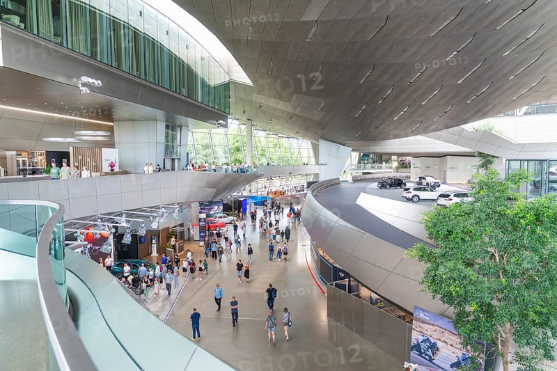 Large, modern showroom with visitors and various cars, BMW Welt, Munich, Germany