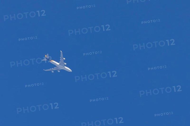 Boeing 747 jumbo jet cargo aircraft of UPS United Postal Service flying in a blue sky, England, United Kingdom