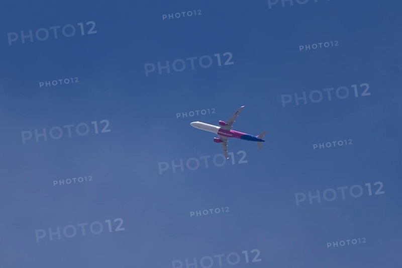 Airbus A321 jet aircraft of Wizz Air airlines in flight in a blue sky, England, United Kingdom