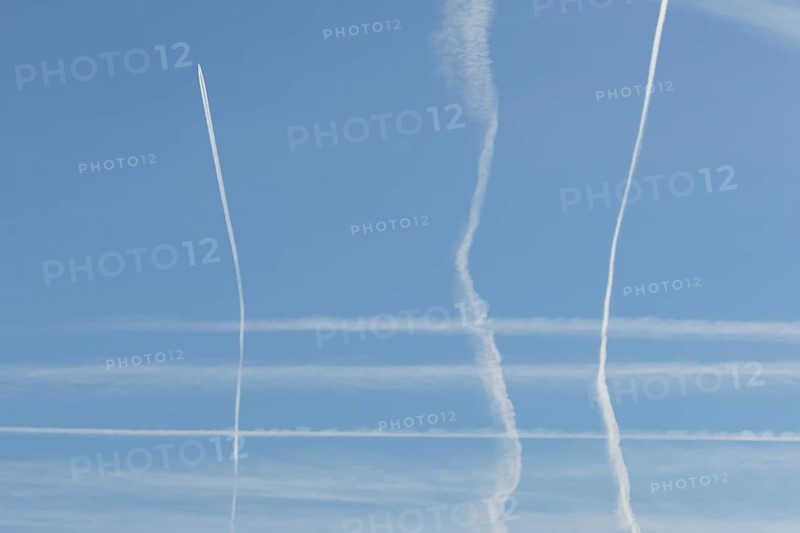 Jet aircraft vapour trails or contrails in a blue sky, England, United Kingdom