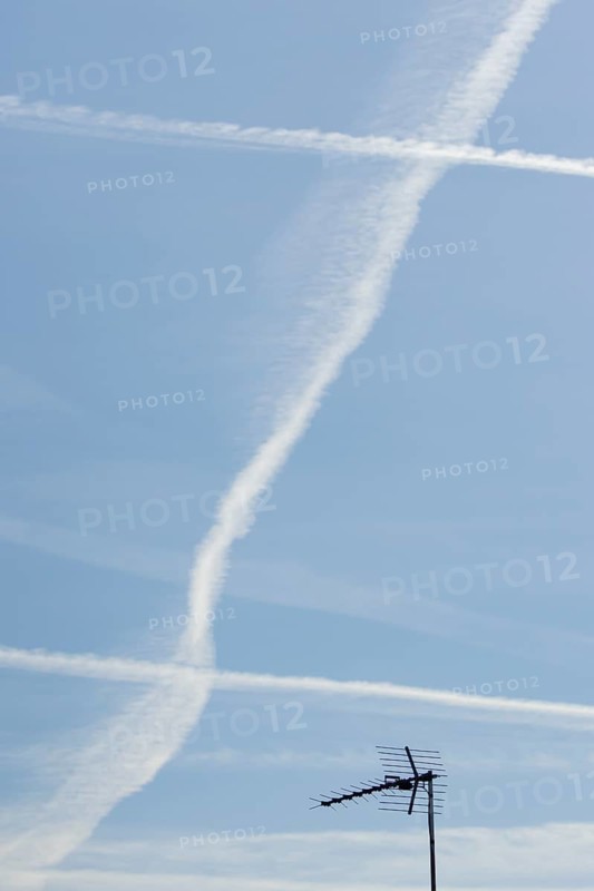 Jet aircraft vapour trails or contrails in a blue sky, England, United Kingdom