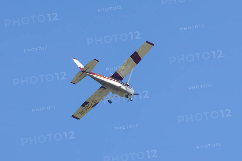 Reims Cessna F172M Skyhawk light aircraft flying in a blue sky, England, United Kingdom
