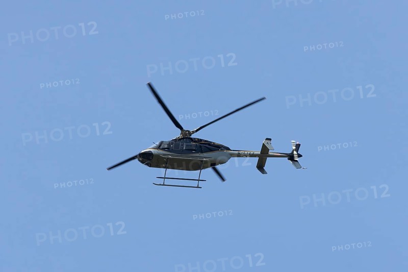 Bell 407GXP jet ranger helicopter flying in a blue sky, England, United Kingdom