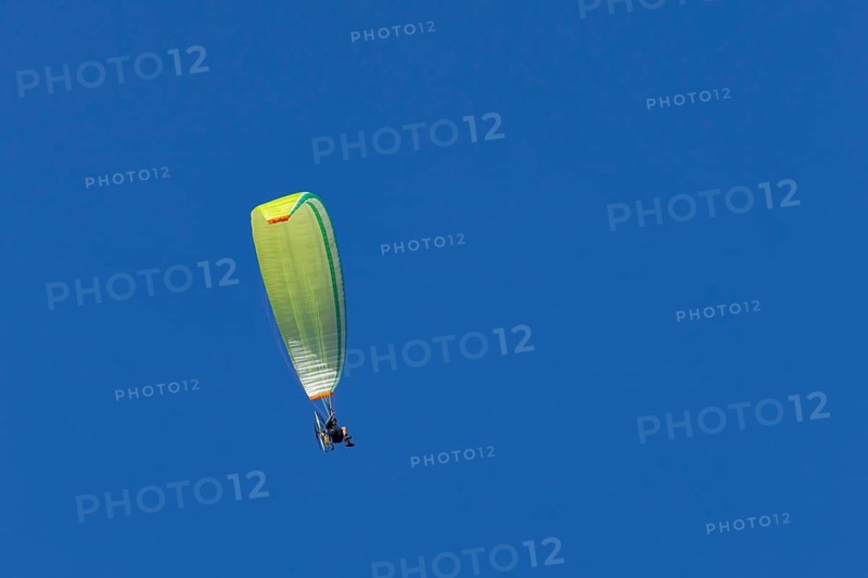 Paraglider flying in a blue sky, England, United Kingdom