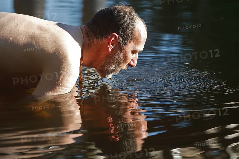 Man in the water during body care while travelling, Müritz National Park, Mecklenburg-Western Pomerania, Germany