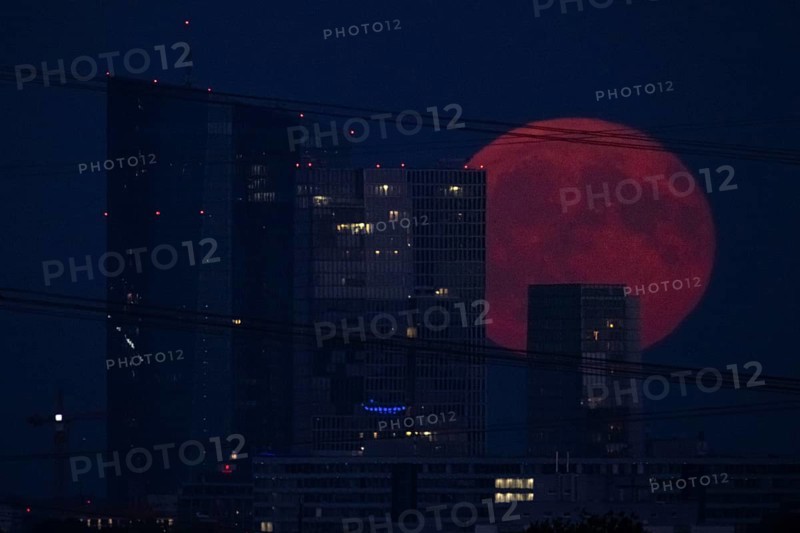 The full moon passes over the Frankfurt banking skyline, Frankfurt am Main, Hesse, Germany