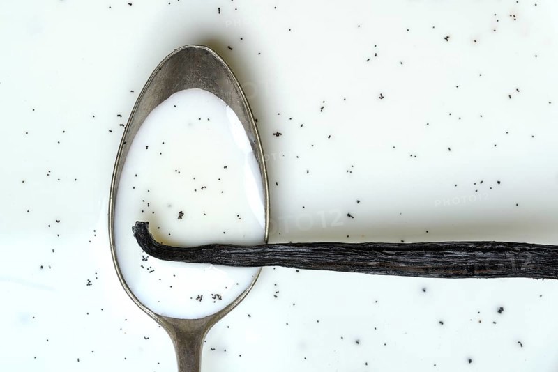 Spoon with vanilla pod, vanilla seeds in milk