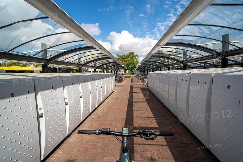 Bicycle parking spaces and boxes on the cycle path in the east of Utrecht, at Utrecht-Lunetten railway station, direct connection of the cycle path to the railway station and bus station, covered bicycle stands, on the Maarschalkerweerdpads cycle path, Netherlands