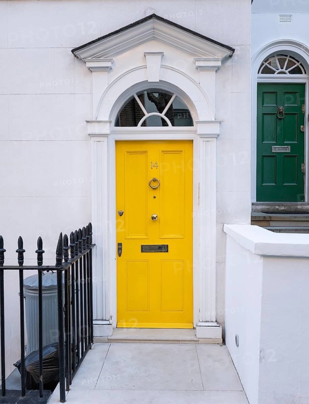 Bright yellow front door with neoclassical triangular pediment, Palladian-style entrance, white façade, Kensington, London, England, United Kingdom