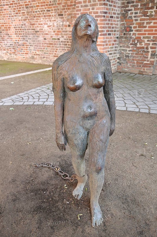 Sculpture Mary Magdalene by Kiki Smith 1994, Wild Woman, bronze sculpture, modern art, female figure with shackles, shackles, bound, chained, chained, attached, chain, naked, standing, life-size, European Hanseatic Museum, Old Town, Lübeck, Schleswig-Holstein, Germany