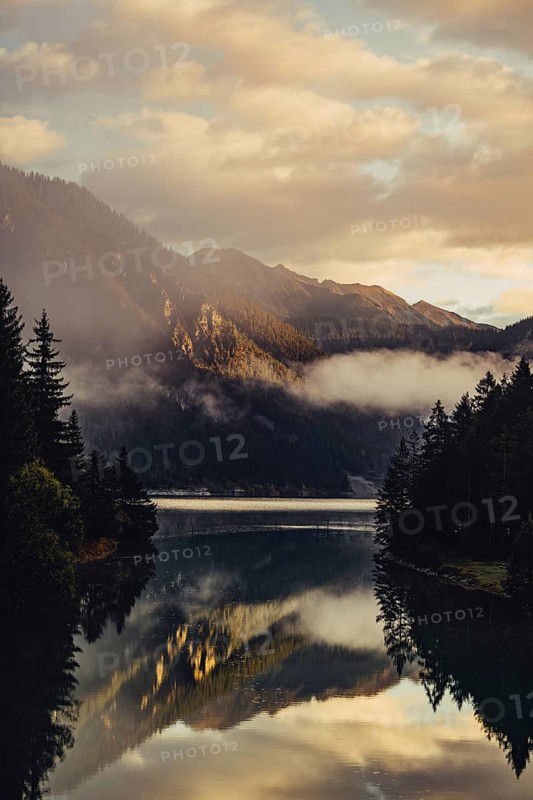 Sunrise with reflections and alpenglow in Lake Heiterwanger See in Tyrol in the Alps in Austria