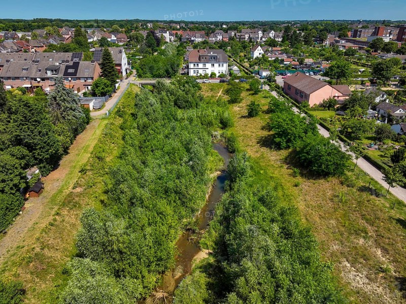 Recklinghausen, North Rhine-Westphalia, Germany - Renaturalised Hellbach, renaturalised watercourse, the Hellbach is now free of wastewater after the construction of a parallel sewer, is part of the Emscher river system and thus part of the Emscher conversion, was previously an open, above-ground wastewater channel, mixed water channel with surface water and wastewater. The renaturalised Hellbach stream strengthens the city's climate resilience, promotes biodiversity and helps to mitigate urban warming caused by climate change