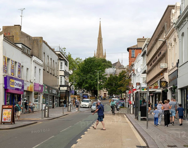 Shops in street of historic buildings, Union Street, Torquay, Devon, England, UK view to church spire
